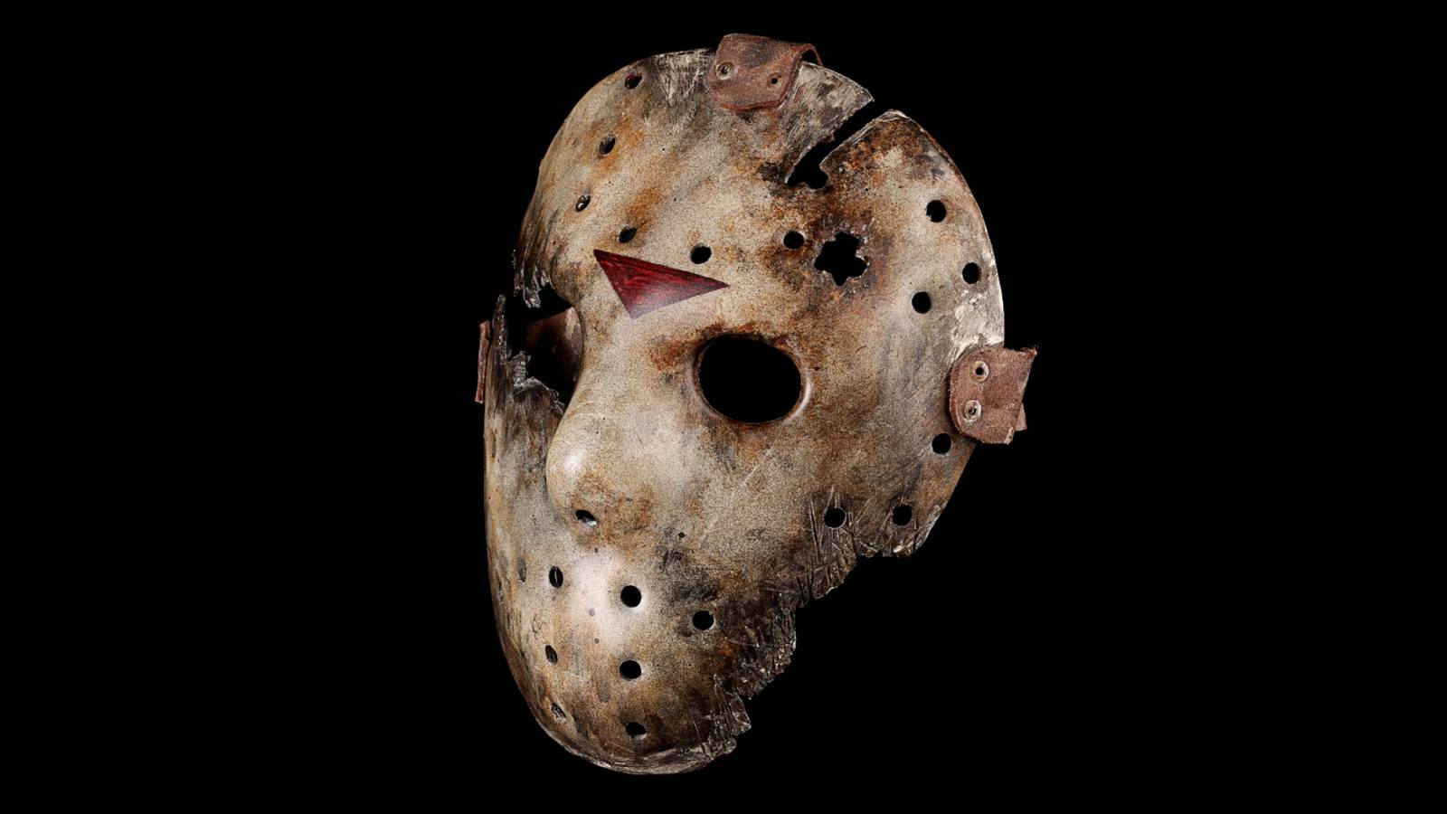 A prop Jason Voorheen mask photographed in front of a black background