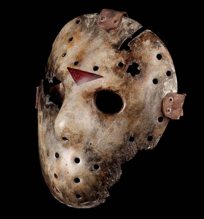 A prop Jason Voorheen mask photographed in front of a black background