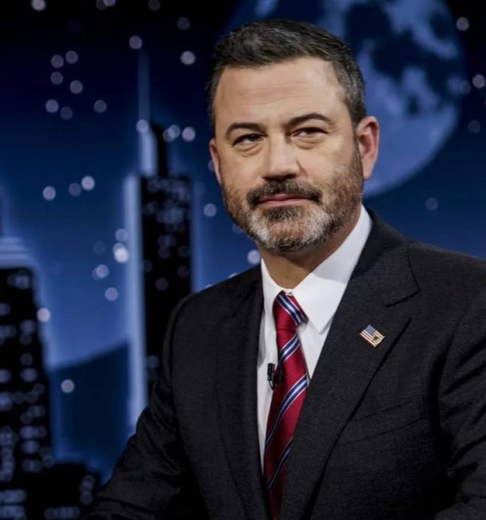 Jimmy Kimmel sitting at his desk with a serious look on his face